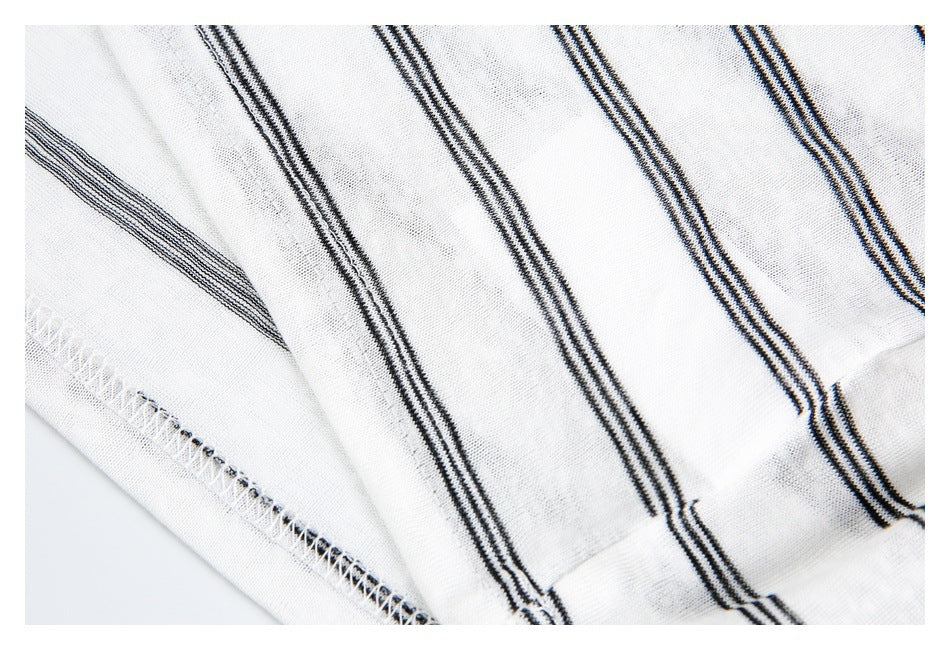 Close-up of black stripes on white knit fabric beside a finished seam.