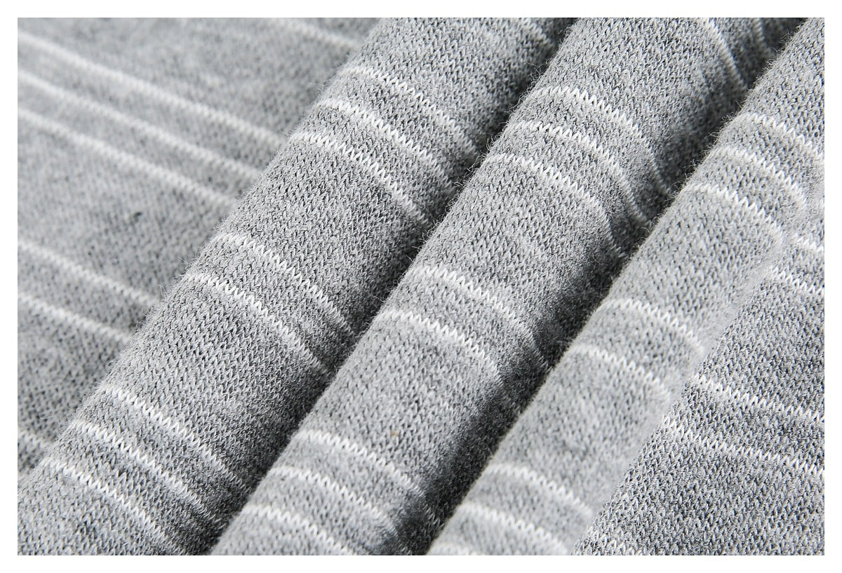 Close-up of folded gray knit fabric showing its textured weave and thin white stripes.