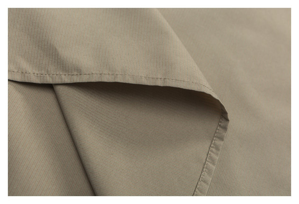 Close-up of beige fabric showing a folded edge and stitched hem.