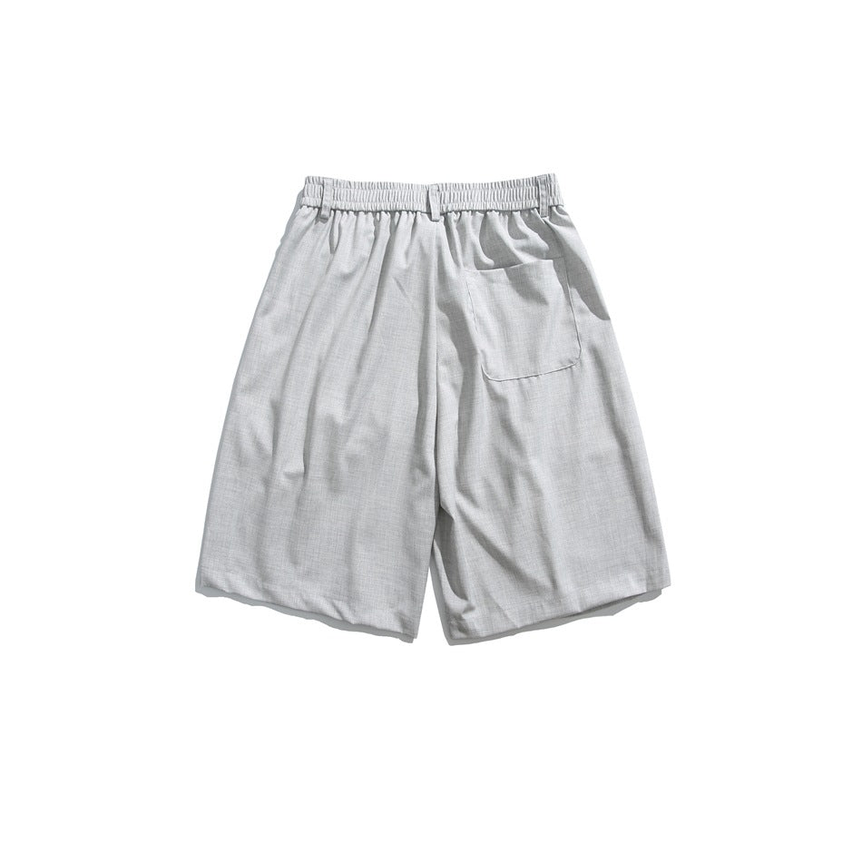 Back view of light gray knee-length shorts with elastic waistband and one patch pocket