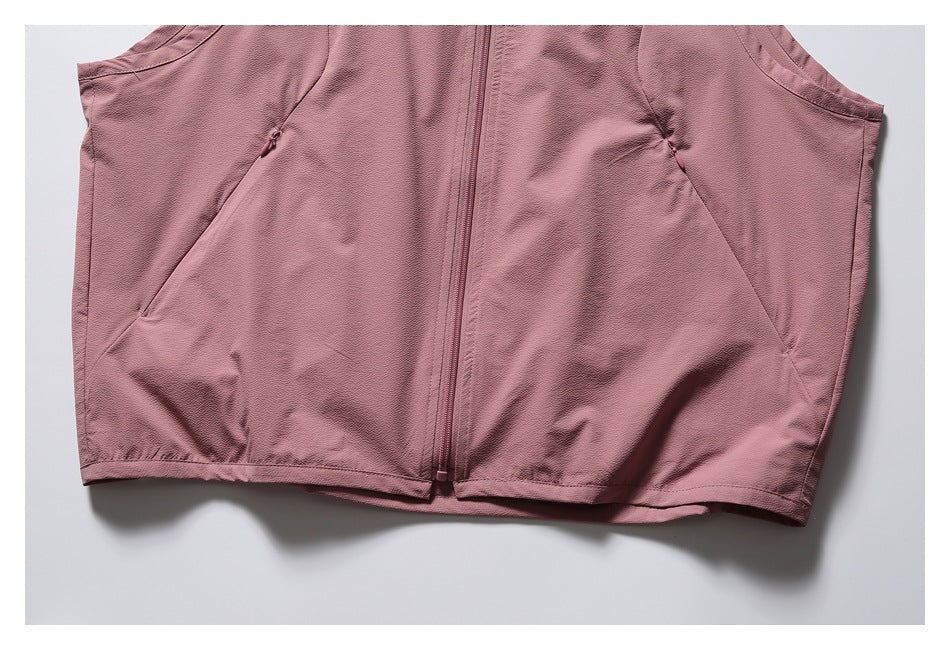Close-up of the dusty rose vest's lower front, showing the center zipper, angled pocket seams and hem.