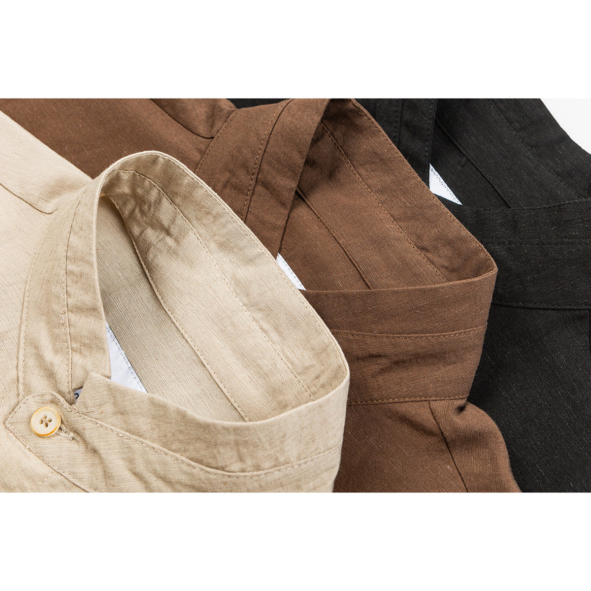 Close-up of beige, brown, and black short-sleeve shirts showing their collars and button details.