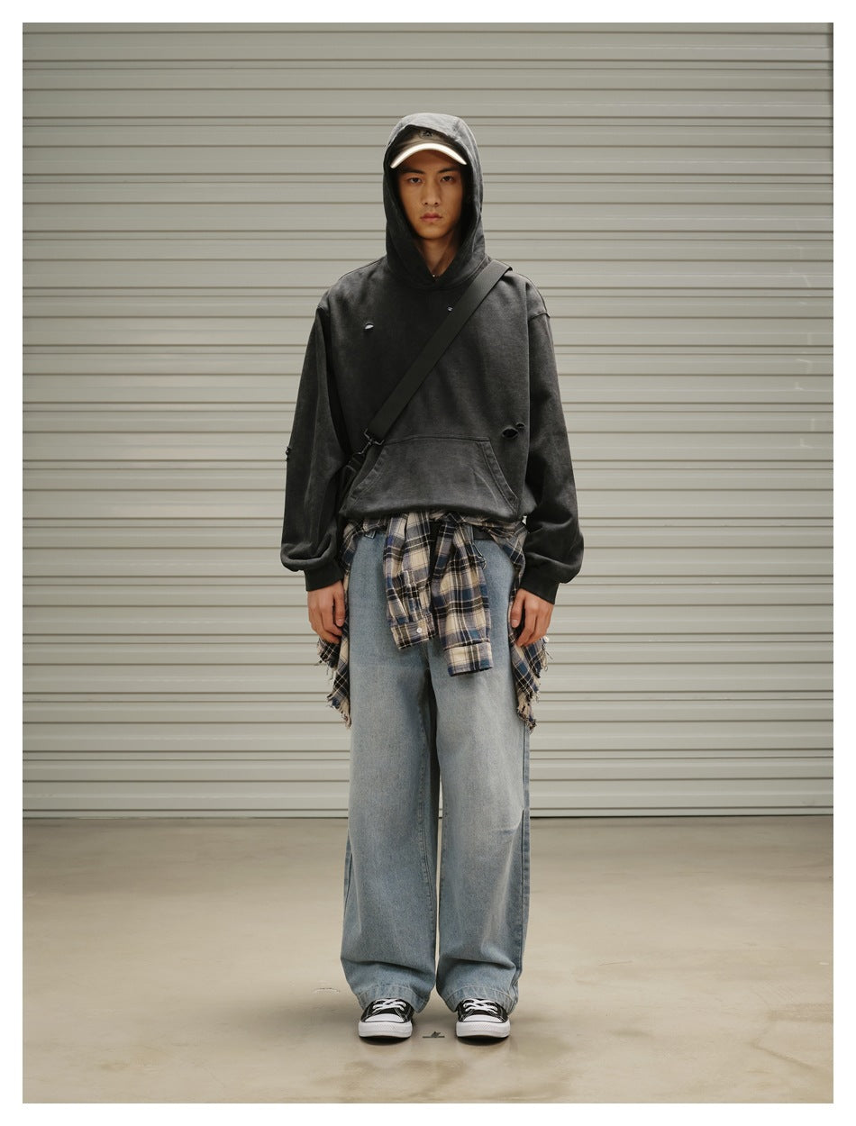 Model wearing light blue wide-leg jeans with a gray hoodie, plaid shirt tied at the waist and black sneakers
