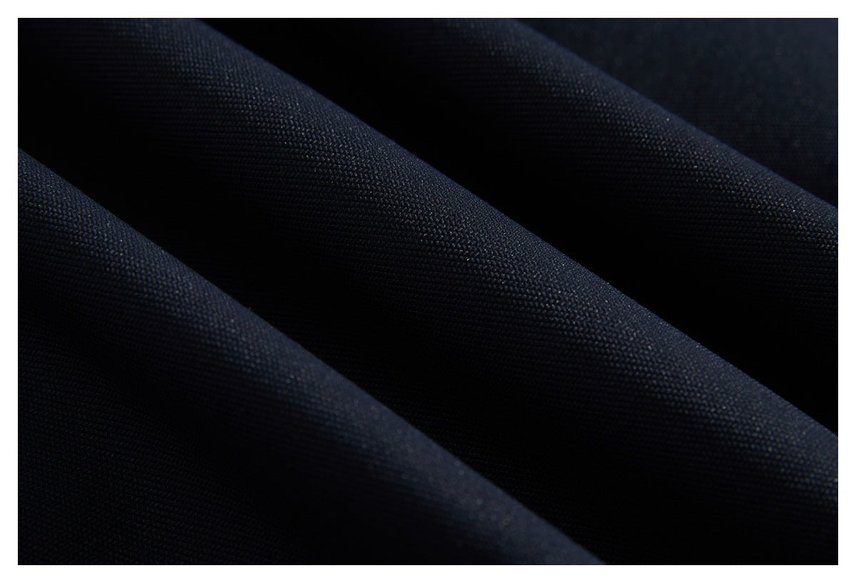 Close-up of dark navy-black fabric with a fine, tightly woven texture and soft folds.