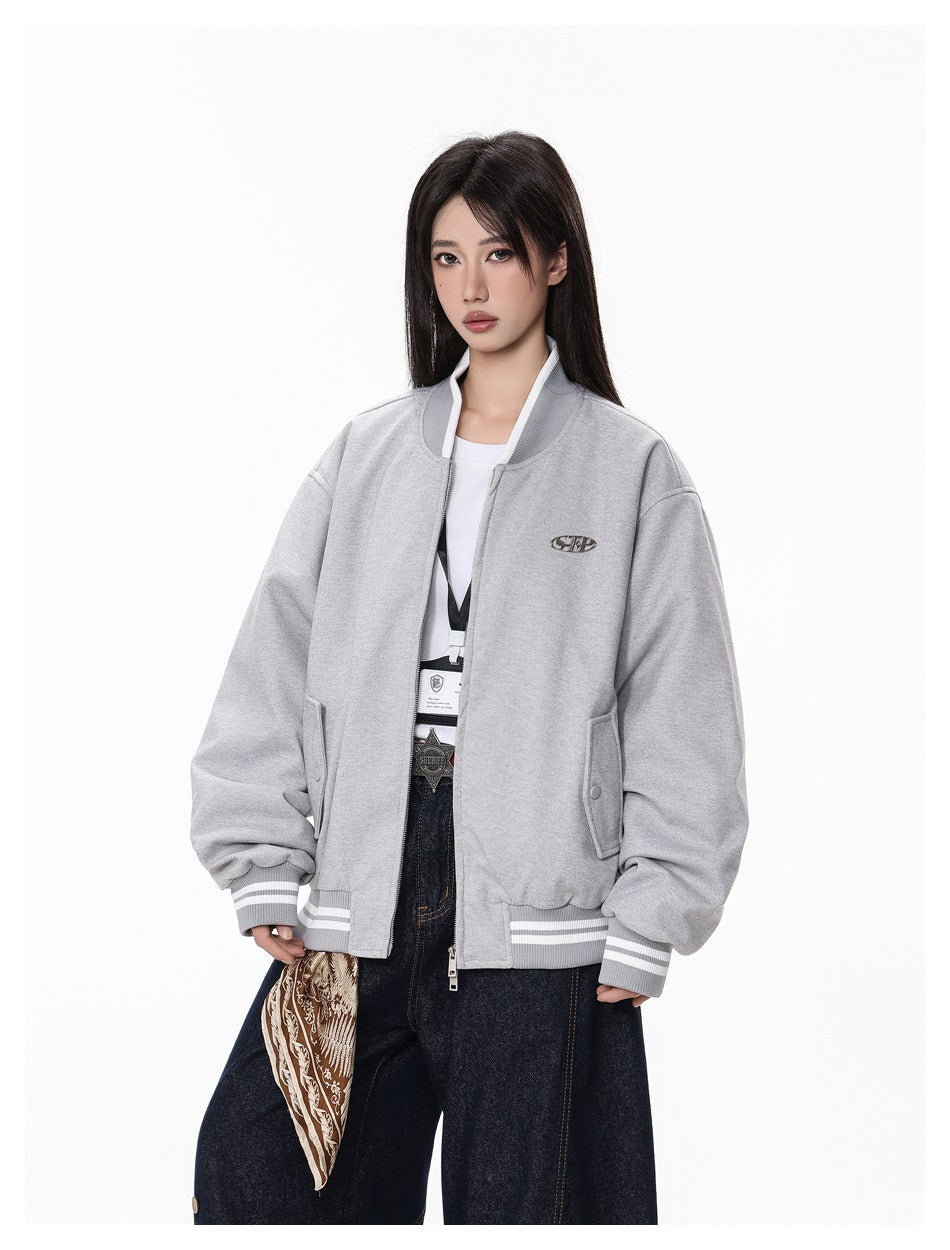 Model wearing an open light gray bomber jacket with striped ribbing, front pockets, and a small chest emblem.