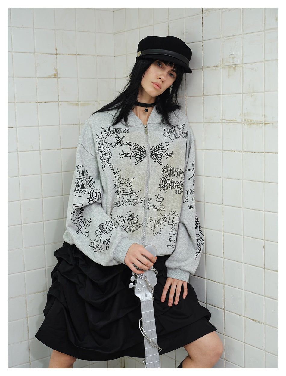 Model in gray graffiti-print zip hoodie, black cap and black ruched skirt, leaning on a tiled wall holding a silver guitar