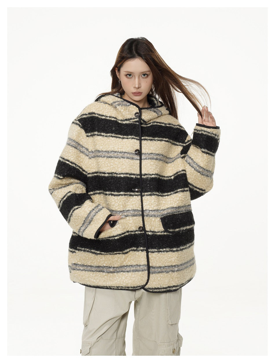 Model wearing a cream, black, and gray striped hooded jacket with dark trim and beige cargo pants, front view.