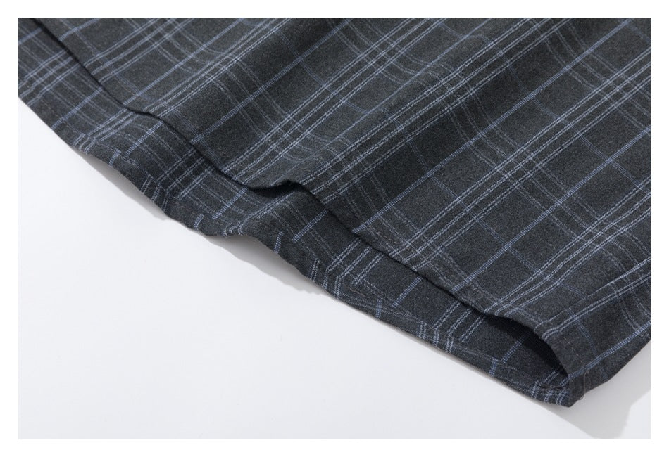 Close-up of the hem of dark charcoal plaid garment with thin blue-gray lines.