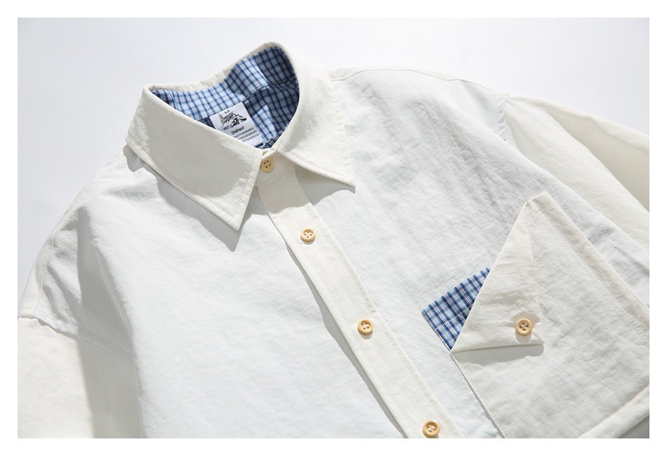Close-up of an off-white shirt collar, button placket, and pocket with blue checked lining.