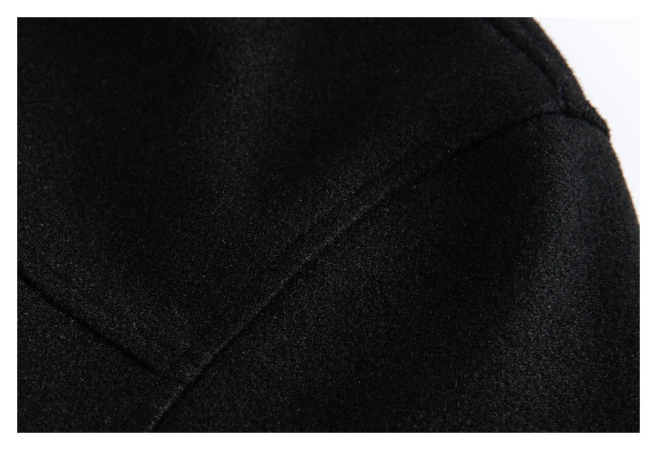 Close-up of black garment fabric with a curved stitched seam.