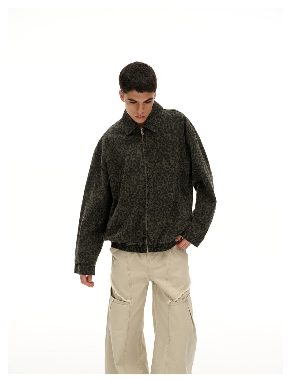 Model wearing a zipped dark olive leopard-print jacket with a pointed collar and loose beige trousers.