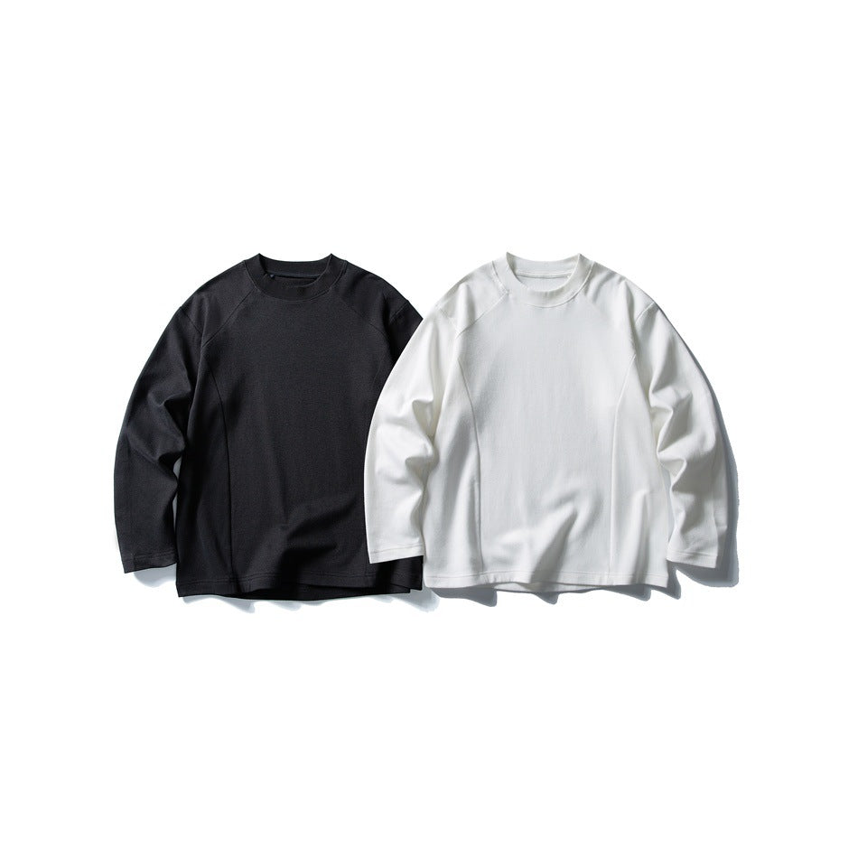 Front view of two long-sleeve crewneck sweatshirts, one black and one white, displayed side by side.