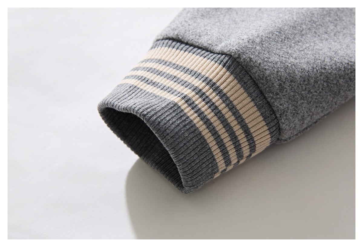 Close-up of a gray sleeve cuff with ribbing and cream and charcoal stripes.