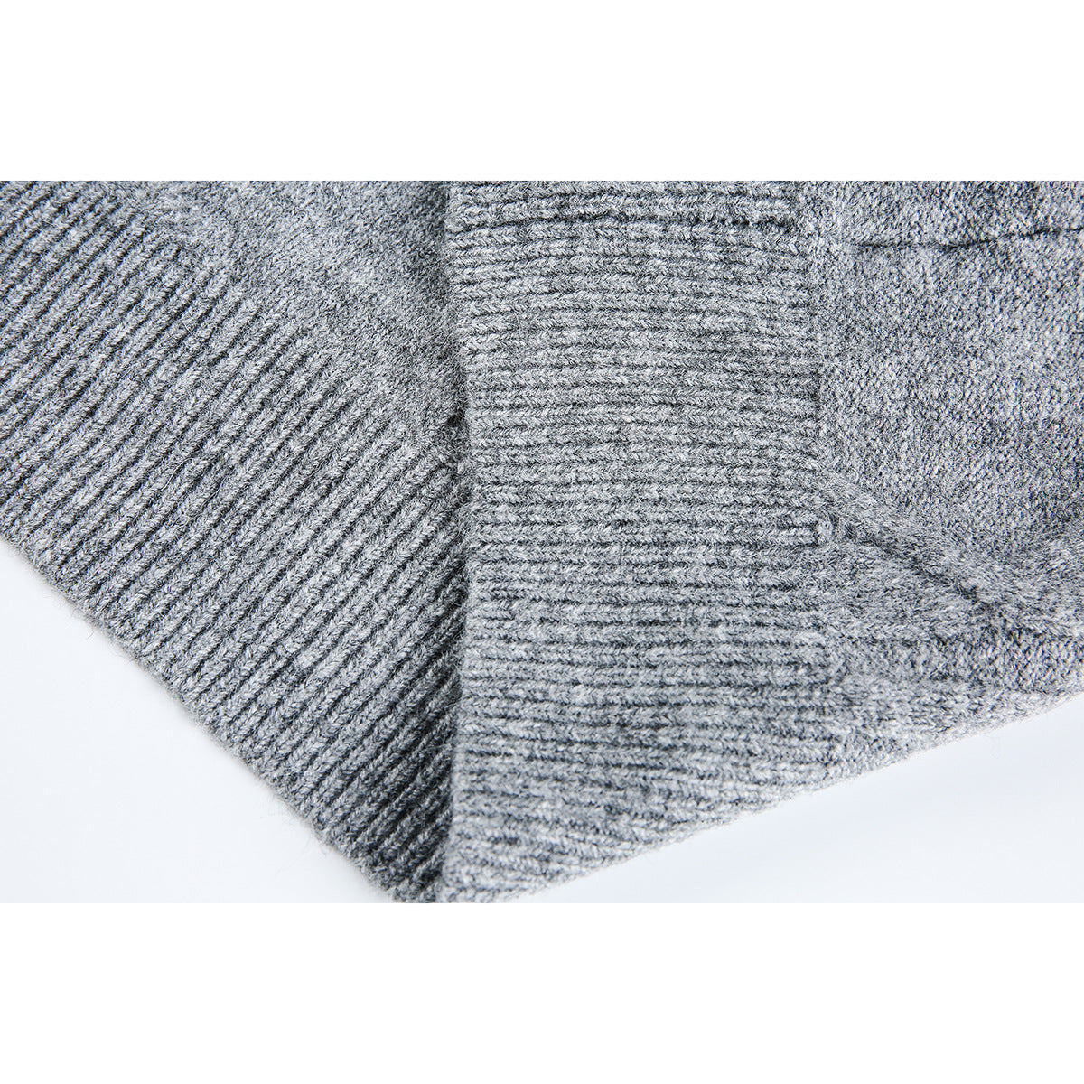 Close-up of a gray sweater's ribbed hem and textured knit pattern.