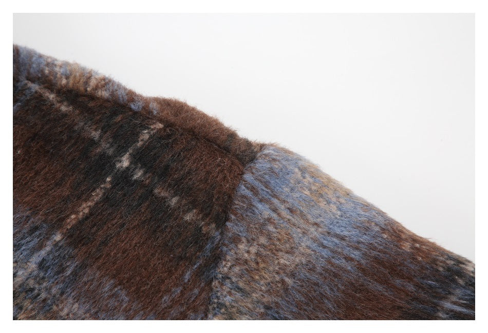 Close-up of the brown-and-blue plaid fabric and shoulder seam.