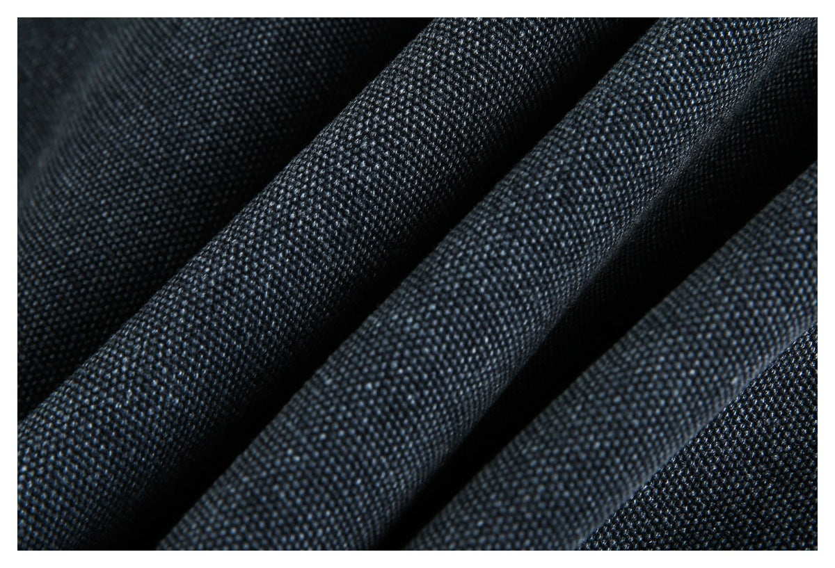Macro view of dark charcoal-blue fabric with a small, raised woven texture and soft folds.
