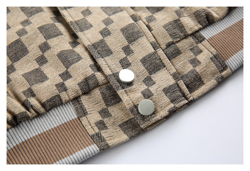 Close-up of a beige and charcoal check jacket with two silver snap buttons and striped trim.