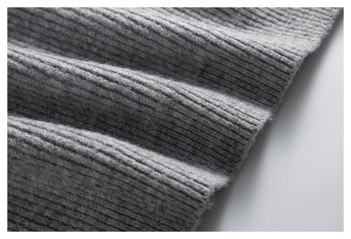 Close-up of gray ribbed knit fabric showing its raised texture and folded edge.