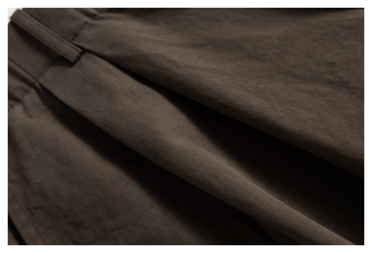 Close-up of brown trouser fabric and a stitched fold.