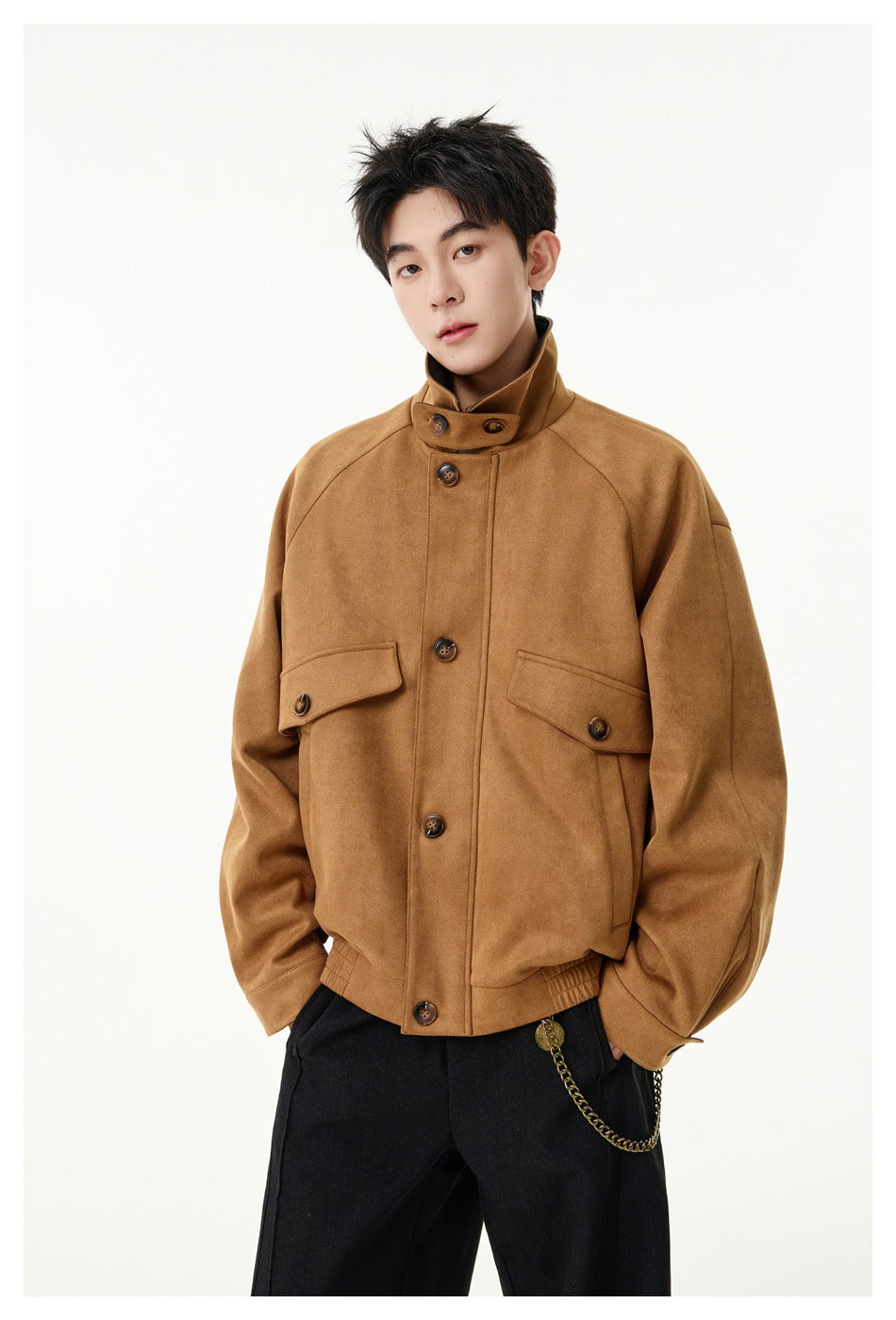 Model wearing a tan-brown jacket with a high buttoned collar, flap pockets and black trousers.