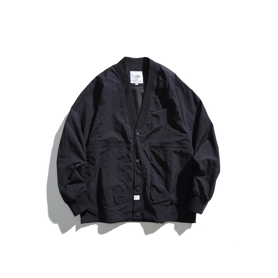 Black V-neck snap-front jacket with ribbed trim, large front pockets and ribbed cuffs, laid flat