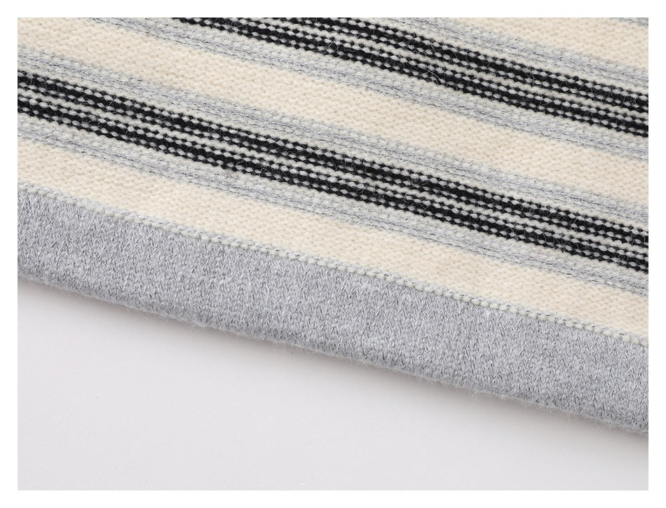 Close-up of the cream sweater's striped knit and wide gray ribbed hem.