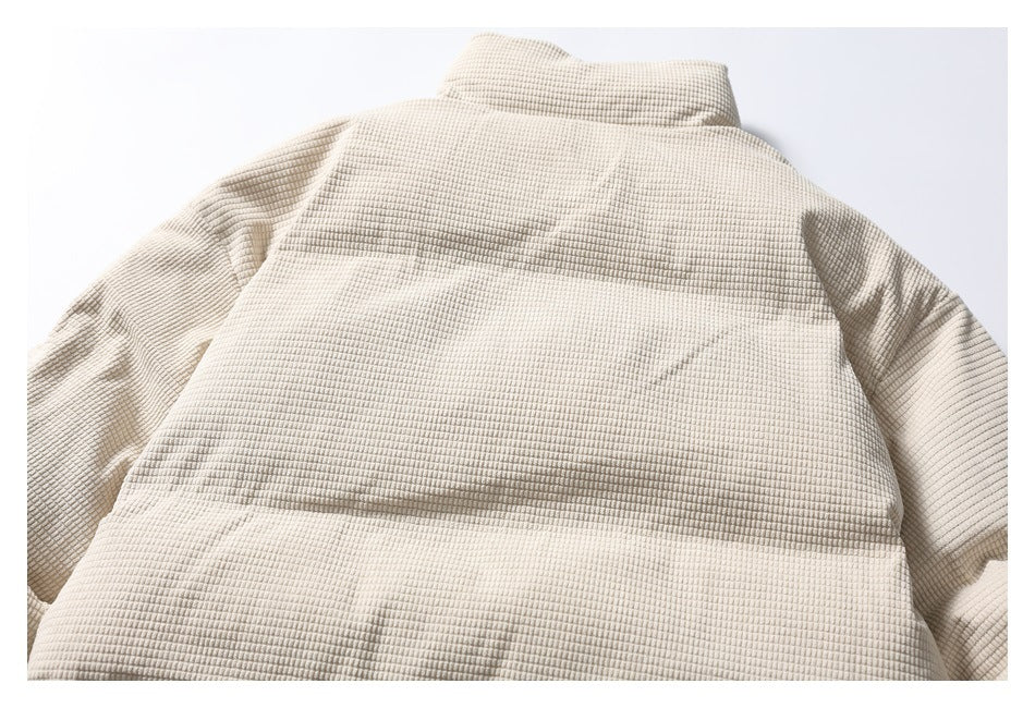 Flat-lay back view of a beige jacket with a raised collar, long sleeves, and a textured grid pattern.