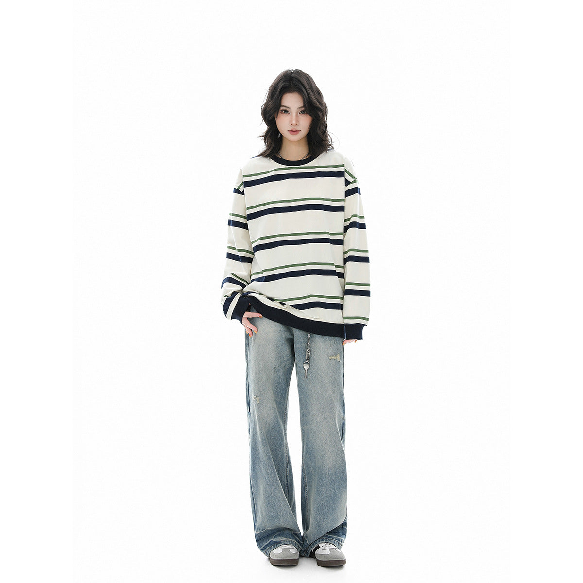 Model wearing an ivory oversized long-sleeve shirt with navy and green stripes and dark ribbed trim.