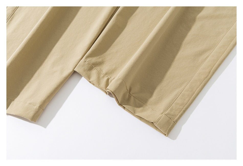 Close-up of the stitched hems and lower legs of tan pants.