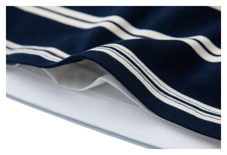 Close-up of the layered shirt’s striped navy hem and white underside stitching.