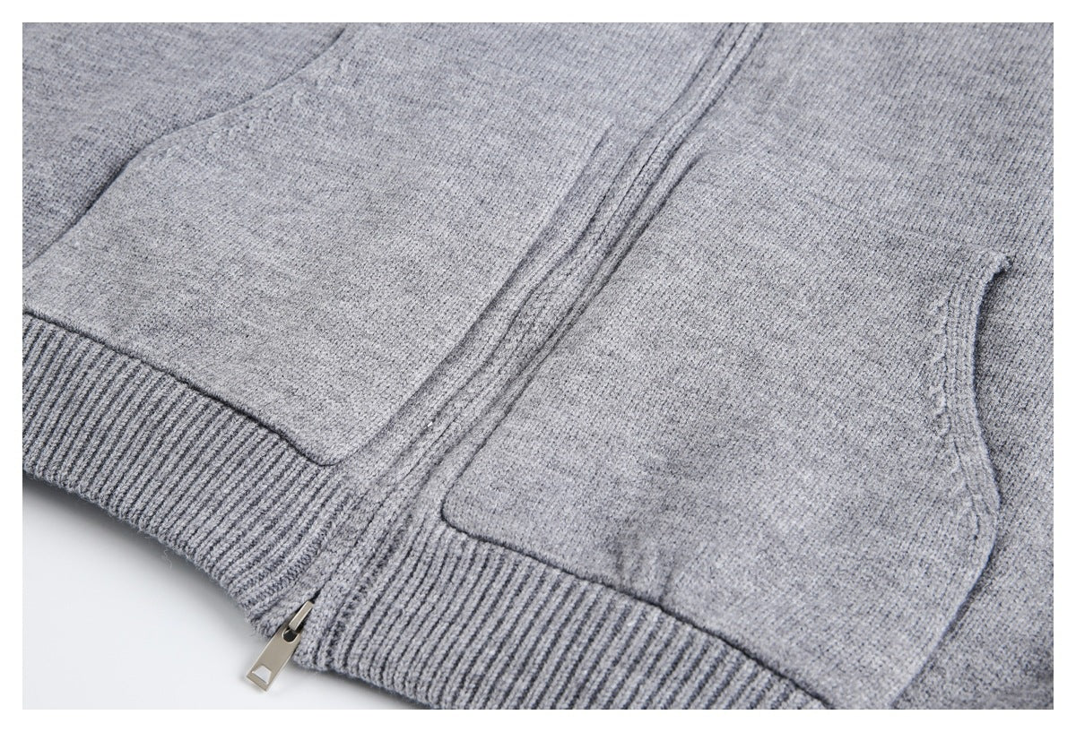 Close-up of the gray knit jacket's front pockets, center zipper, and ribbed hem.