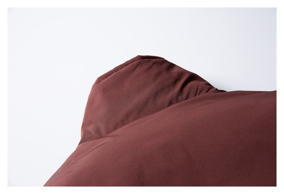 Close-up of a burgundy garment showing a raised folded section and smooth stitched fabric.