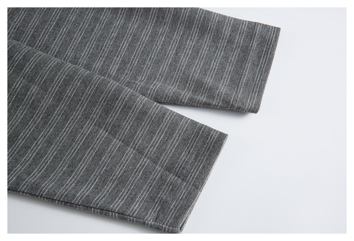 Close-up of the striped charcoal gray shirt's stitched sleeve edges.