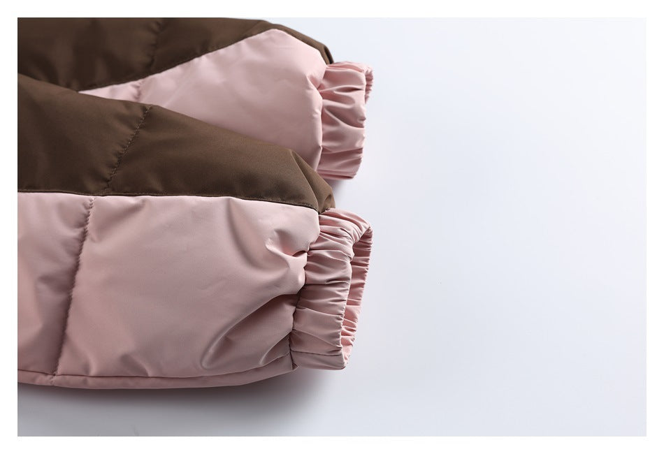 Close-up of a padded jacket showing a dusty pink gathered cuff and pink panels beside a dark brown section.