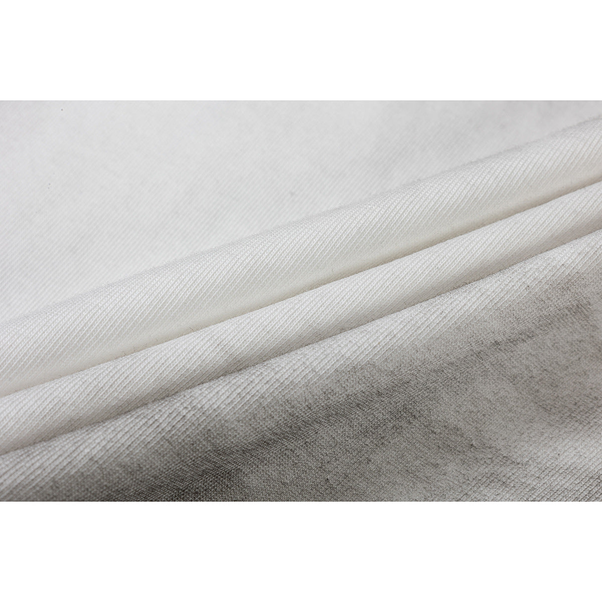 Close-up of folded white and gray T-shirt fabric showing the knit texture.