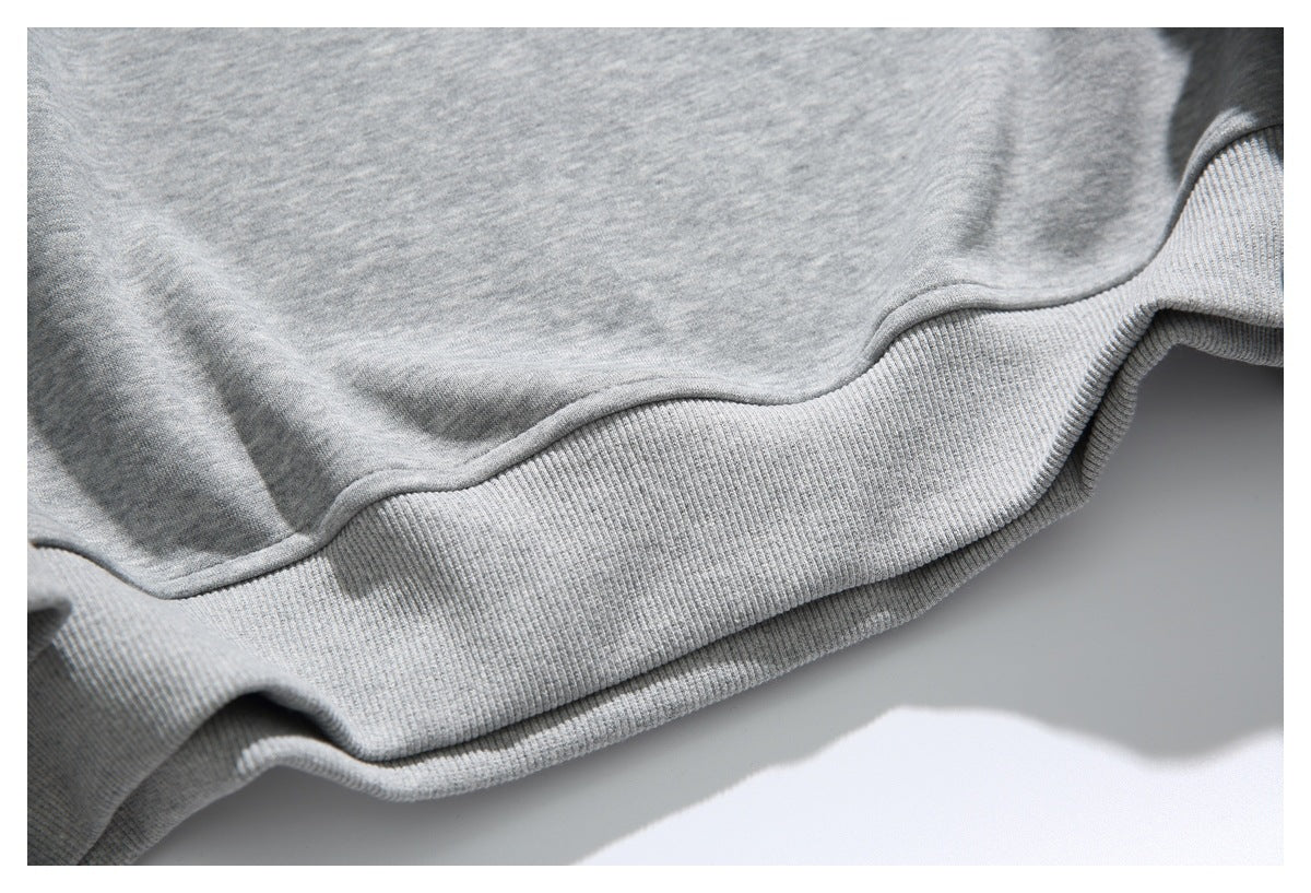 Close-up of the heather-gray sweatshirt's ribbed lower hem and stitched edge.