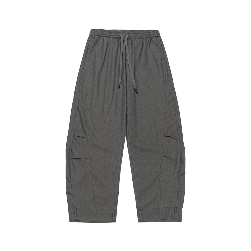 Gray wide-leg drawstring pants, front flat lay with curved seams, side pleats and tabbed hem cuffs