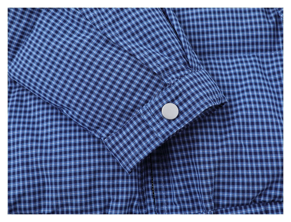 Close-up of a blue checked jacket sleeve cuff with a single snap button.