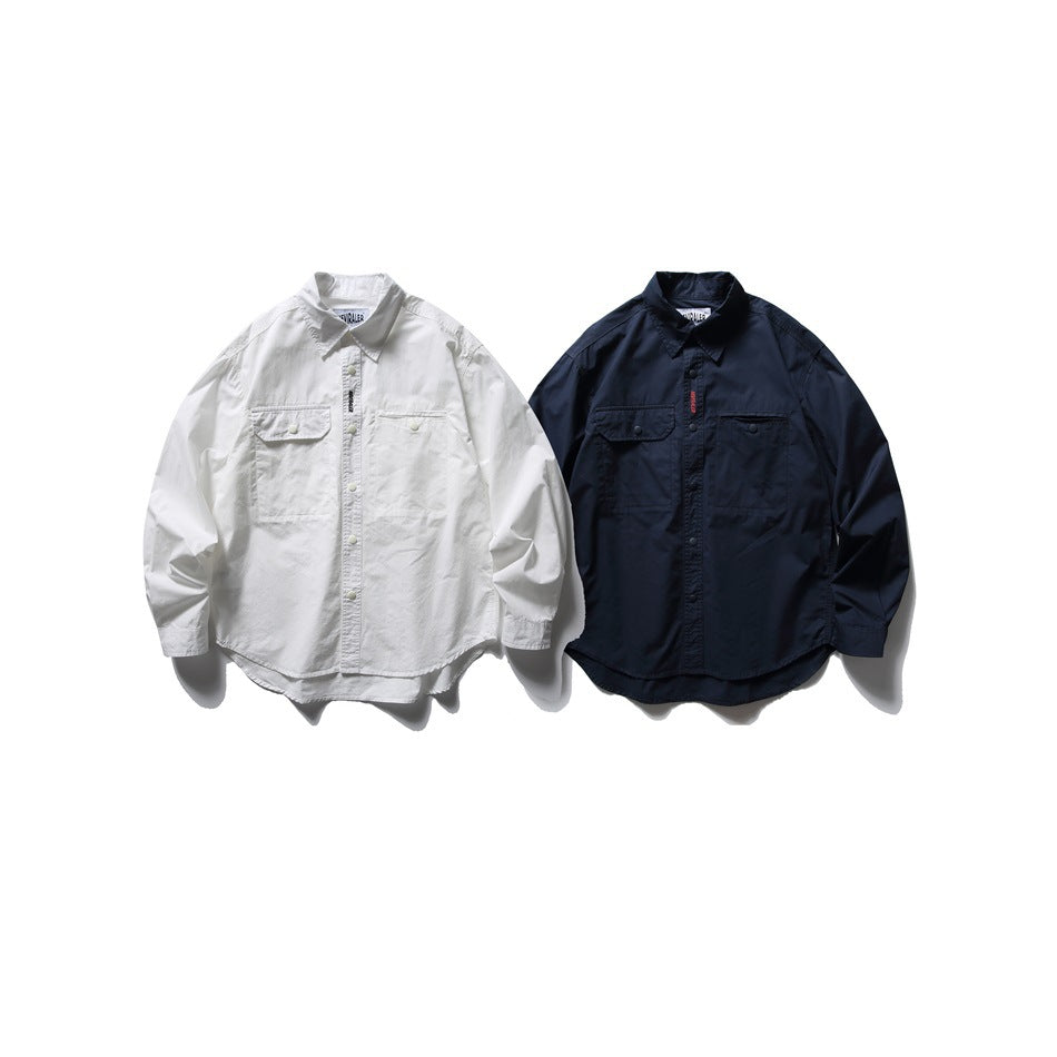 Two flat-lay long-sleeve button-up shirts with pointed collars and chest pockets, one white and one dark navy.