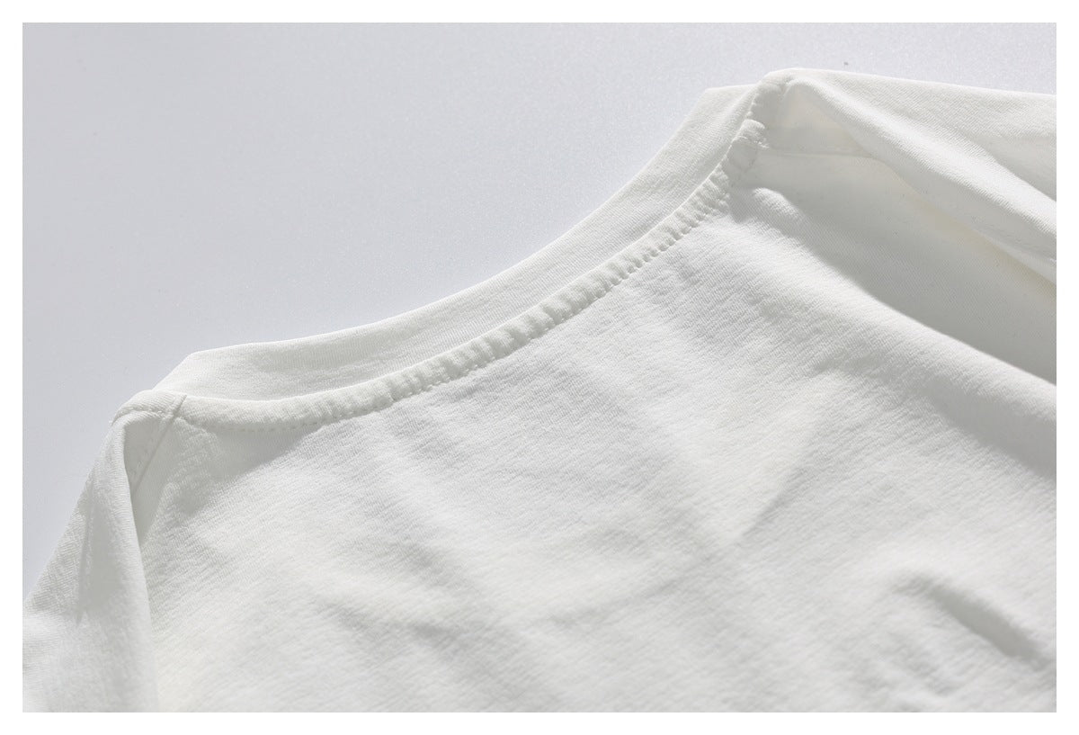 Close-up of the crew neckline and shoulder seam of a white shirt laid flat.