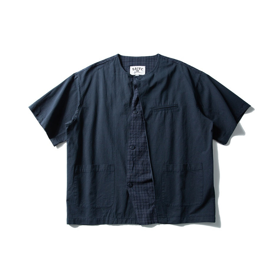 Navy blue short-sleeve collarless button-front shirt with plaid placket panel, chest welt pocket and two patch pockets, flat