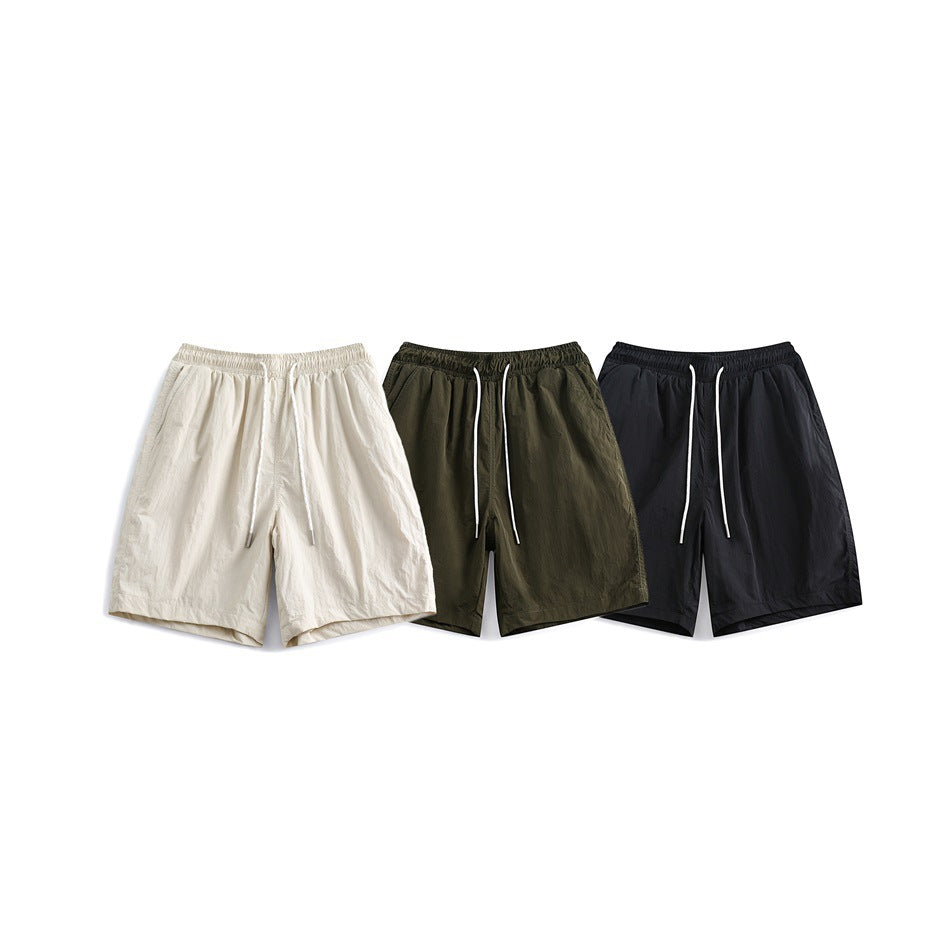 Front view of elastic-waist shorts with white drawstrings in cream, olive, and black.