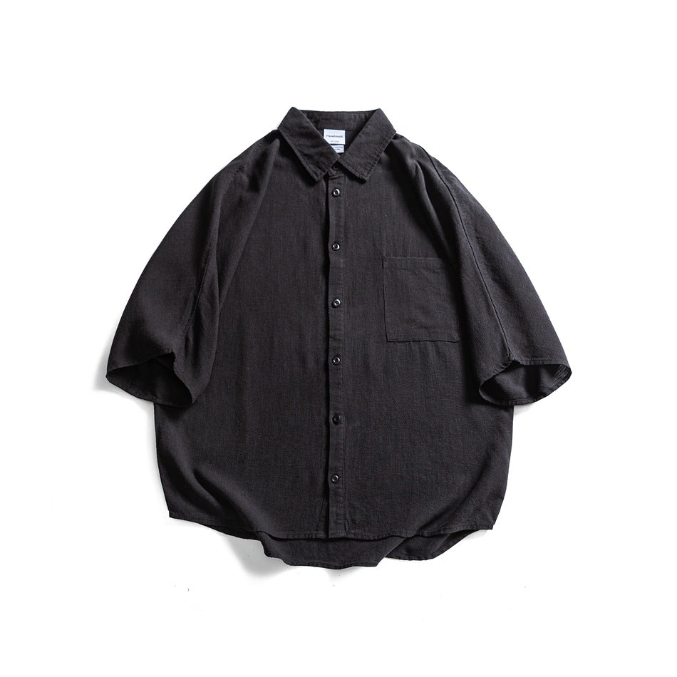 Black short-sleeve button-front shirt with collar and chest pocket, flat lay front view