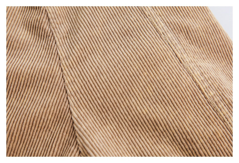 Close-up of tan corduroy fabric with parallel ribs and a stitched seam.