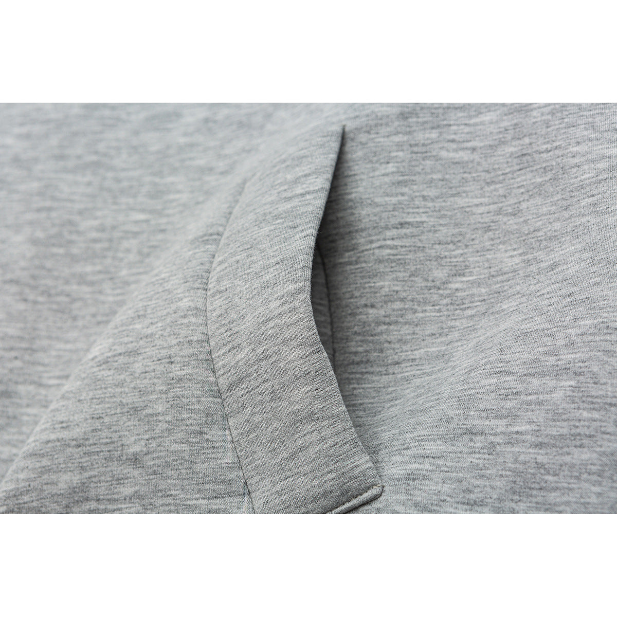 Close-up of a stitched panel seam on heather gray fabric.