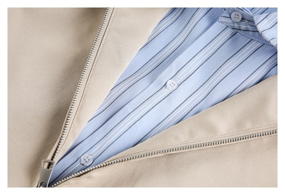 Open beige jacket zipper reveals a light blue vertically striped button-front panel.
