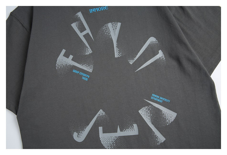 Charcoal T-shirt detail showing a large pale geometric print and small blue English lettering.