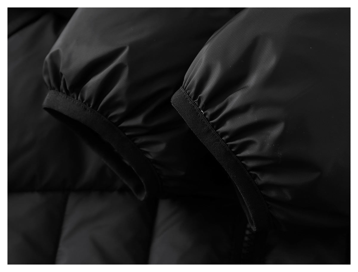 Close-up of black gathered fabric with narrow stitched bands and elastic ruching.