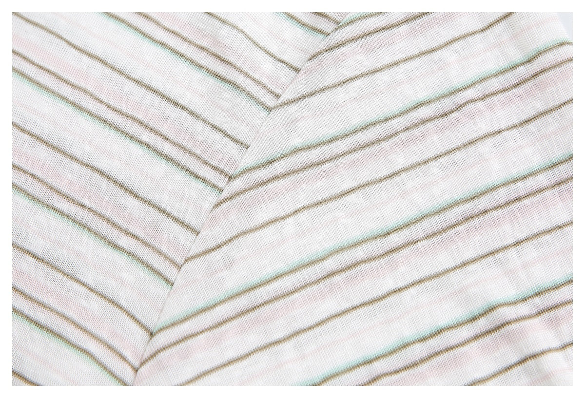 Close-up of fine muted stripes and a stitched seam on the cream shirt.