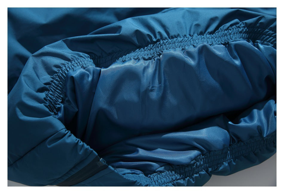 Close-up of blue garment fabric with gathered elastic seams and a small black zipper edge.